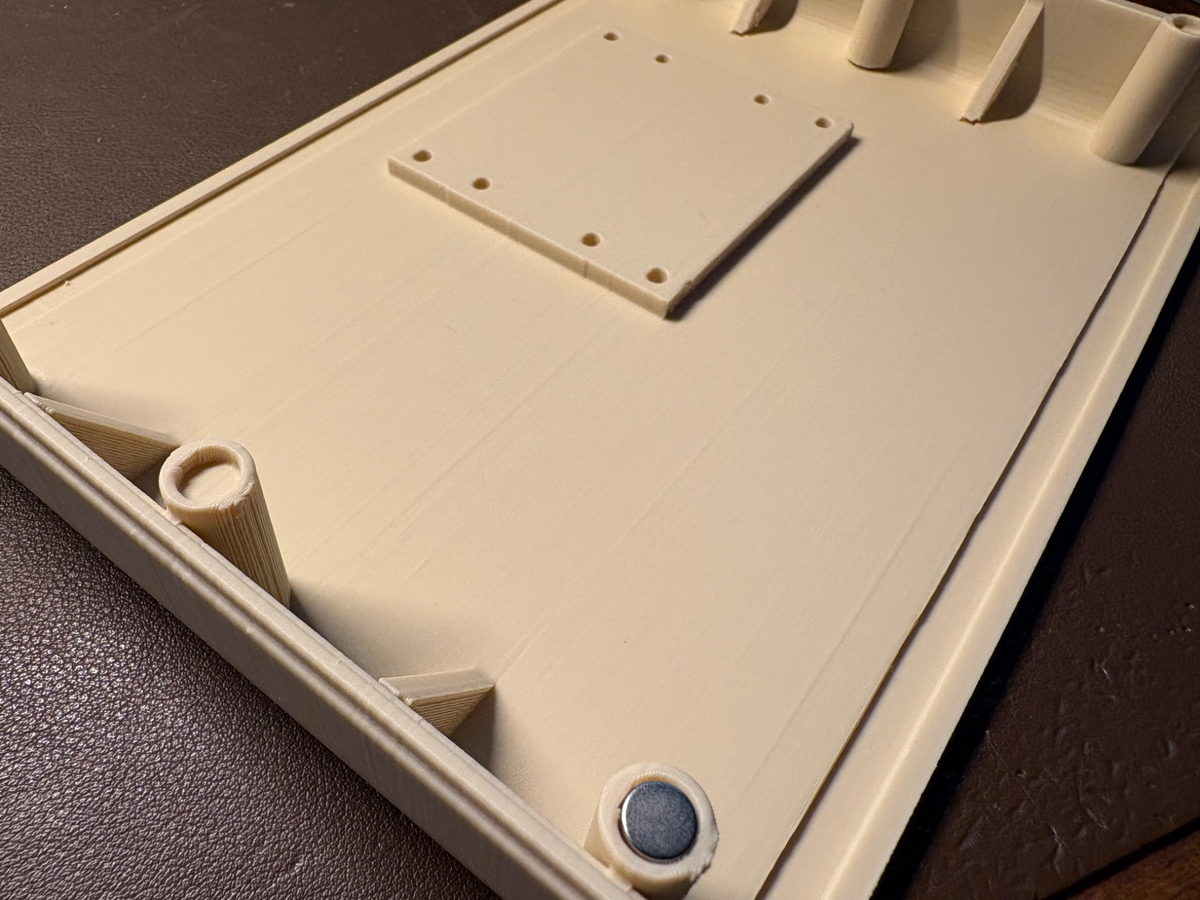 Interior de la carcasa de RetroBox Modem con los alojamientos para imanes de neodimio y la plantilla de montaje para Raspberry Pi.
