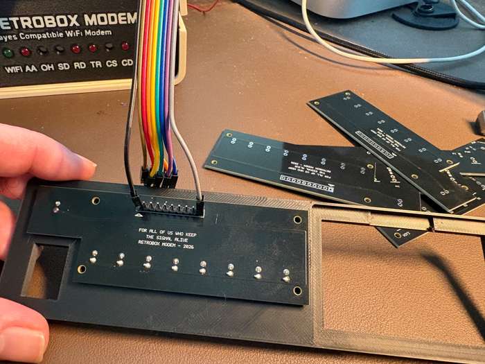 Parte trasera de la PCB de LEDs de RetroBox Modem conectada al mazo de cables durante una prueba con el frontal impreso en 3D.